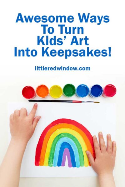kids hands with a set of paints and a painting of a rainbow on a white background
