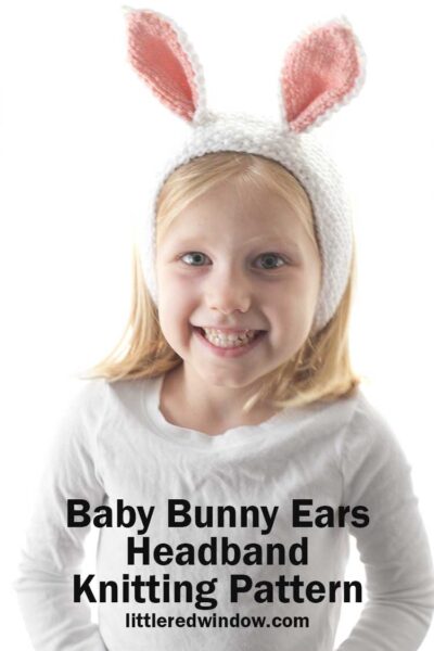 smiling girl in white shirt wearing white knit headband with white and pink bunny ears on top