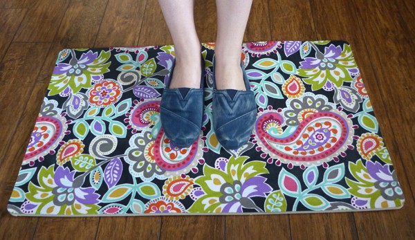 Woman in Toms shoes standing on a bright paisley doormat