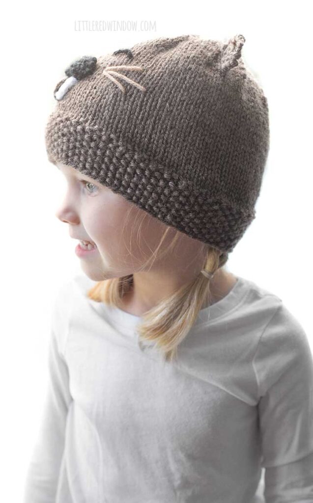 girl in beaver hat looking to the left