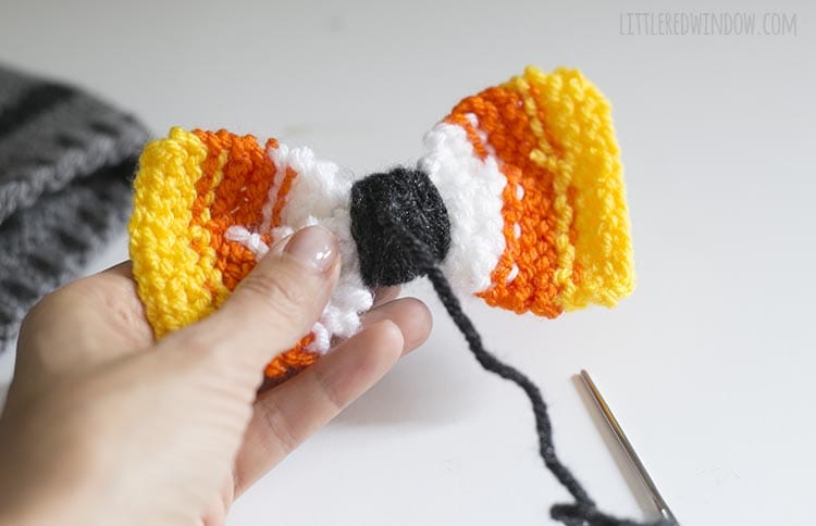 hand holding bow backwards to show yarn knotted at the back of the bow