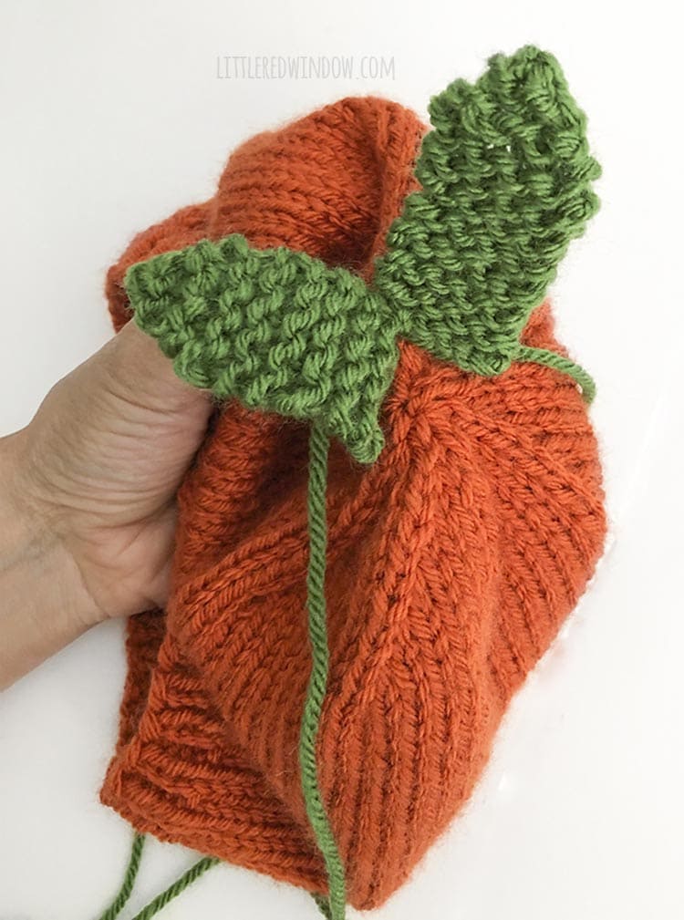 Sew the knit carrot leaves to the top of the baby carrot hat