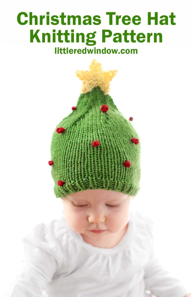 A baby adorably sports a green Christmas tree hat, complete with red bobbles and a yellow star atop, set against a crisp white backdrop. Above reads