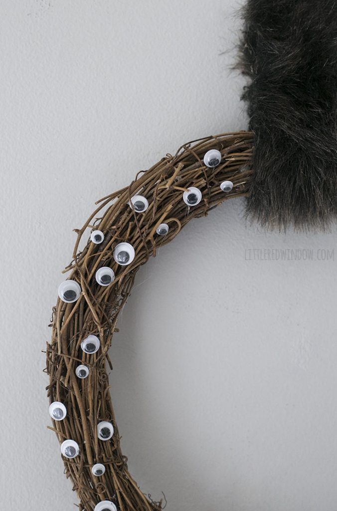 closeup of one quarter of creepy googly eyes wreath with faux fur hanging strip