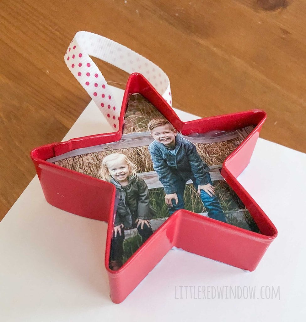 red start shaped cookie cutter photo ornament on top of the back of a piece of scrapbook paper