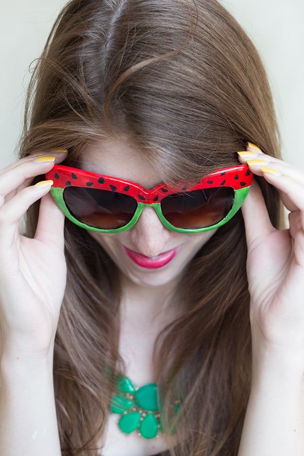 woman looking down and wearing sunglasses painted with watermelon pattern