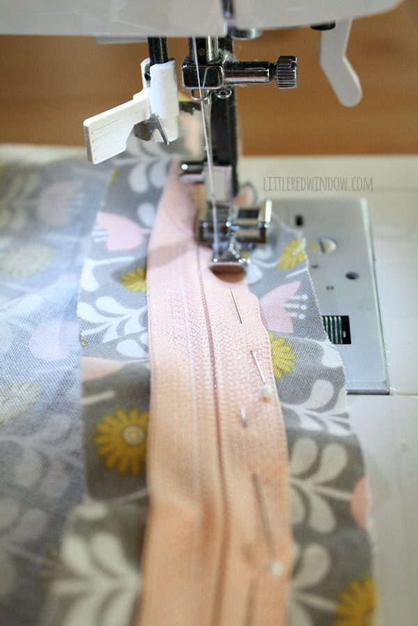 Sewing maching sewing the pink zipper in place