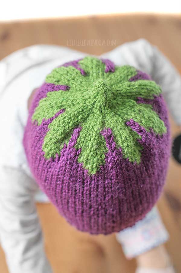 top view close up of the green knit leaves patter on top of the purple knit eggplant hat
