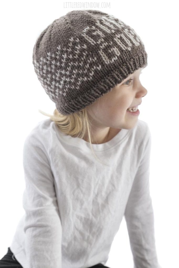 little girl wearing brown knit gobble gobble hat smiling and looking off to the right