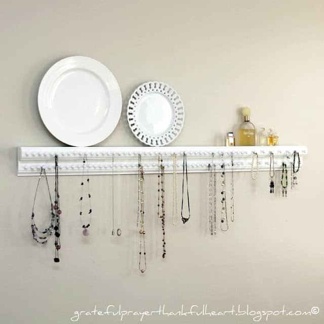 A short piece of white trim attached to the wall with hooks for jewlery and a small ledge on top for plates and perfume
