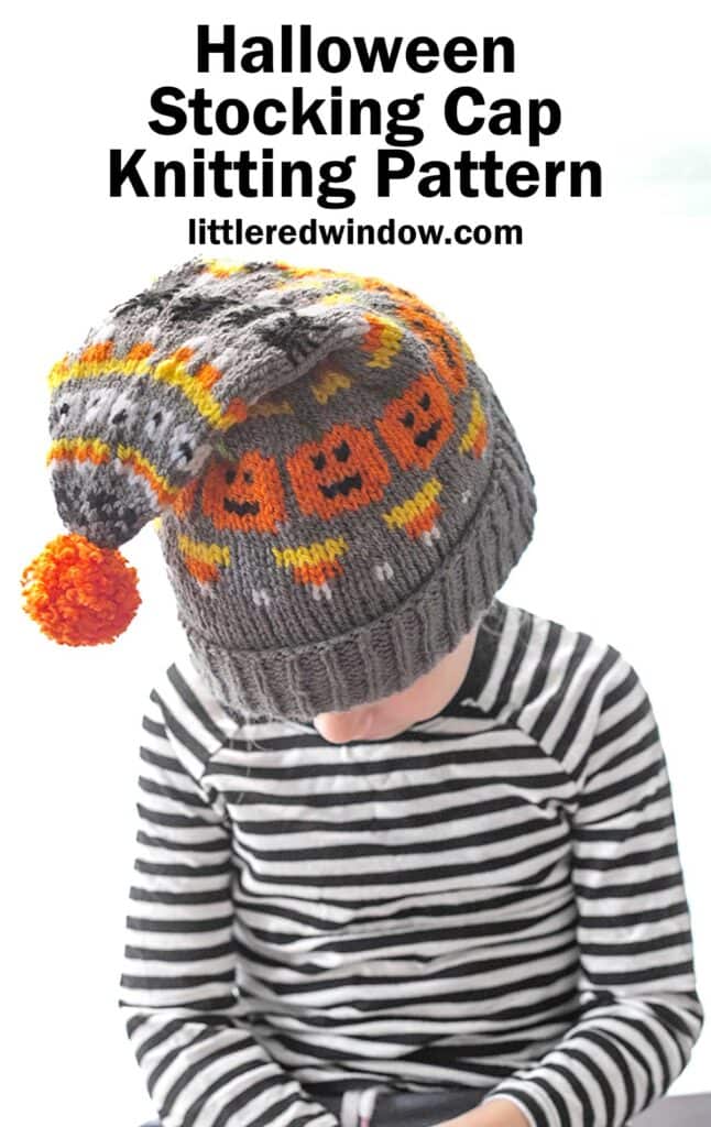 A child wearing a black and white striped shirt looks down, showcasing a gray knit Halloween stocking cap adorned with orange and black pumpkin patterns, candy corns, spiders and an orange pom-pom. The text above reads, "Halloween Stocking Cap Knitting Pattern" with "littleredwindow.com" underneath.