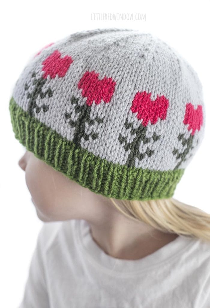 closeup of light blue knit baby hat with heart shaped flowers on it