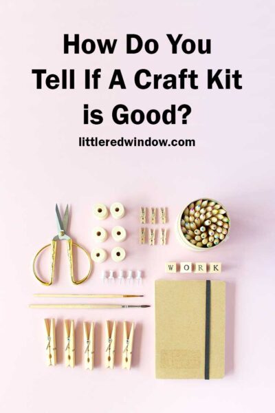 top view of craft supplies including scissors beads clothespins and a notebook in neutral colors laid out in a grid on a light pink surface