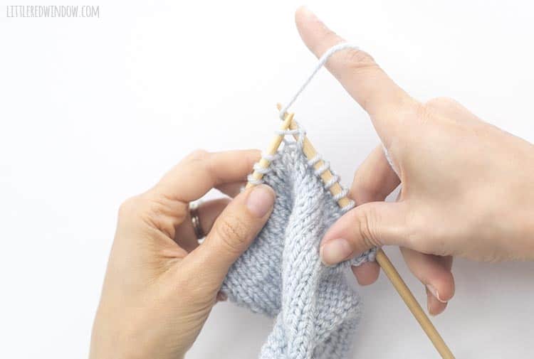 To complete a yarn over, continue on knitting the next stitch while still holding the yarn to the back of the work