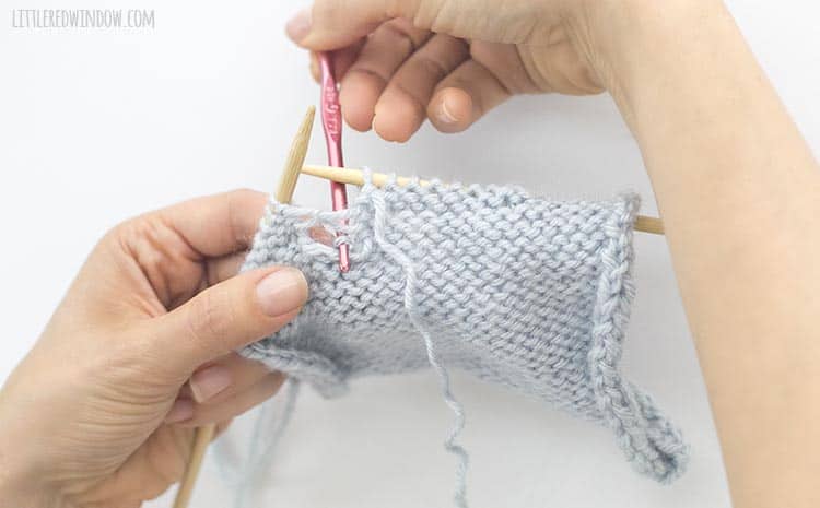Grab the loose yarn and pull through to the back to fix a dropped purl stitch