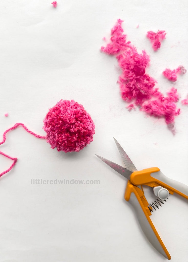 Using sharp shears or scissors, trim the pom pom