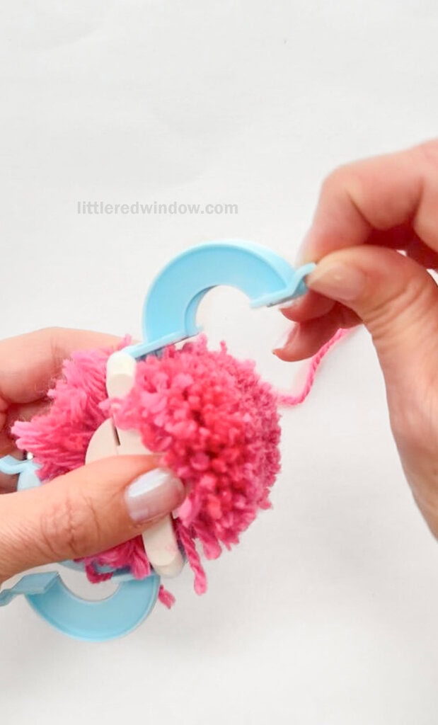 Open the arches on both sides of the pom pom maker again. This may take a little gentle pulling.