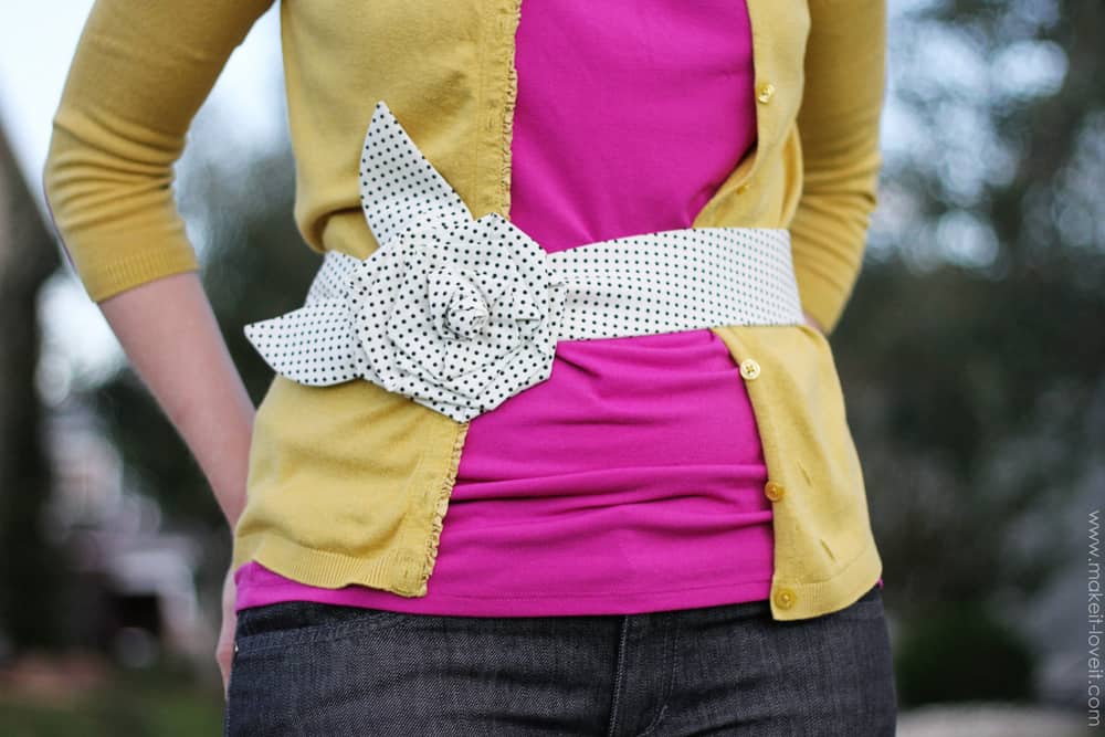 woman wearing white and black polka dot fabric belt with big fabric flowers