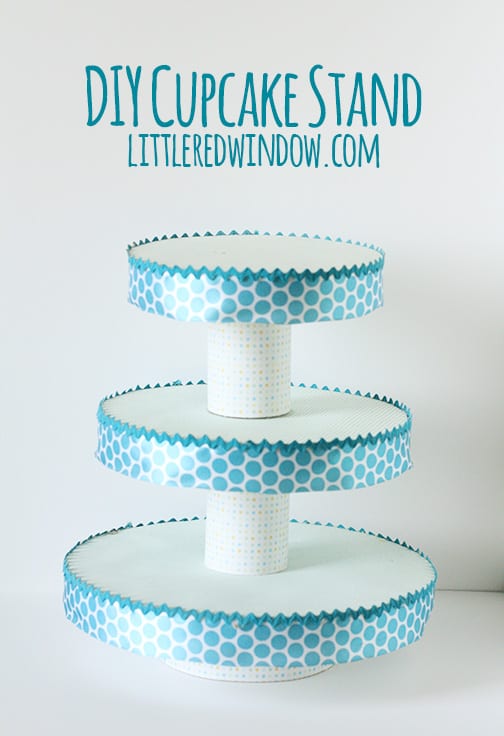 Cupcake stand with three tiers and teal polka dot ribbon around the edges