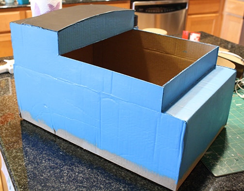 Cardboard box train shape painted blue with a black roof