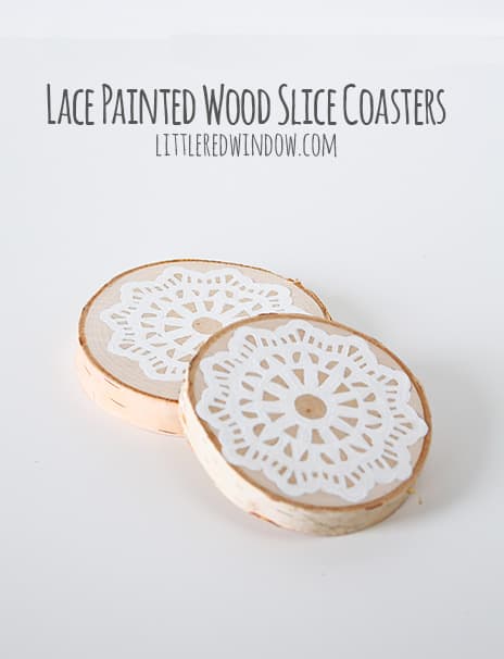 Finished wood slice coasters with painted lace pattern on top in front of a white background