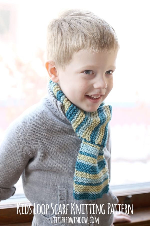 Smiling boy wearing gray sweater and green and blue striped scarf