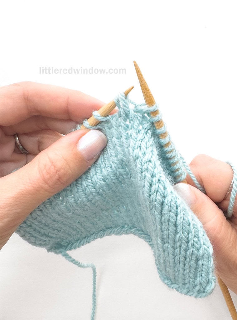 Skip the 1st stitch on the left needle and knit into the BACK of the 2nd, leaving both stitches on the left needle.