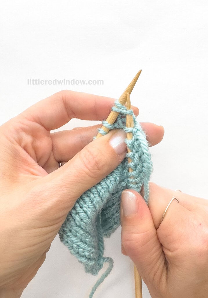 Skip the 1st stitch on the left needle and knit into the FRONT of the 2nd, leaving both stitches on the left needle.