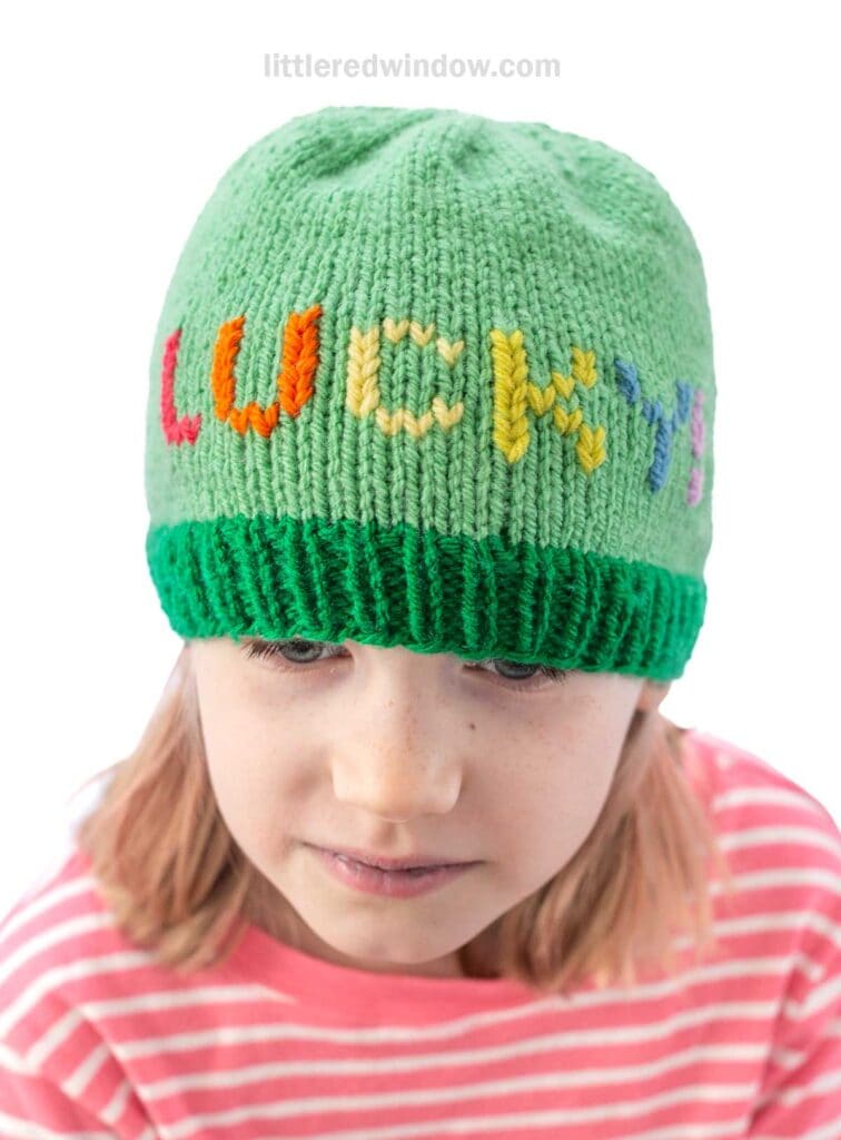 A child wearing a green knit hat with