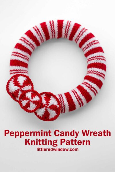 A knitted wreath with red and white peppermint candy stripes, featuring three round pepperming candies. Text reads, "Peppermint Candy & Holly Wreath Knitting Pattern" at littleredwindow.com.