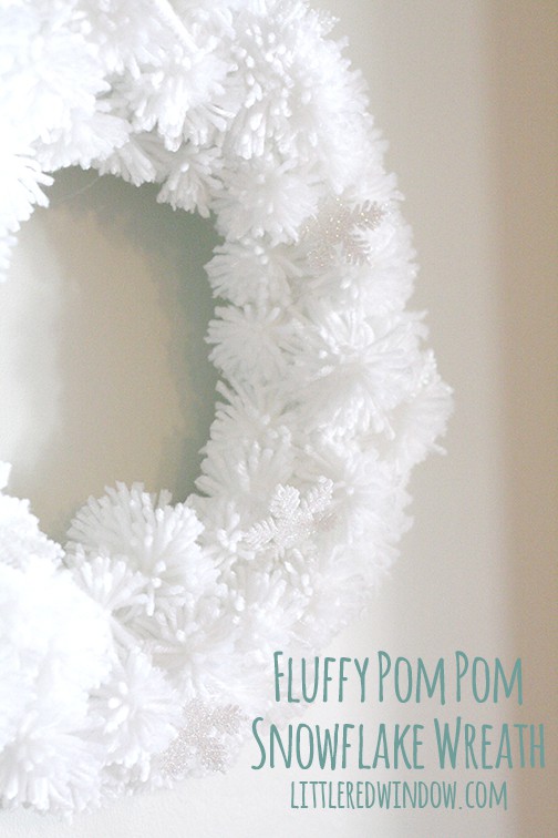 White pom pom wreath hanging on a wall