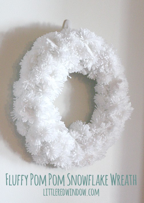 White pom pom wreath hanging on a wall