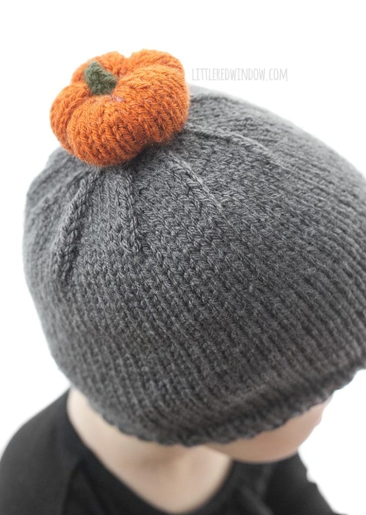Adroable orange knit pumpkin on top of a cute baby pumpkin patch hat