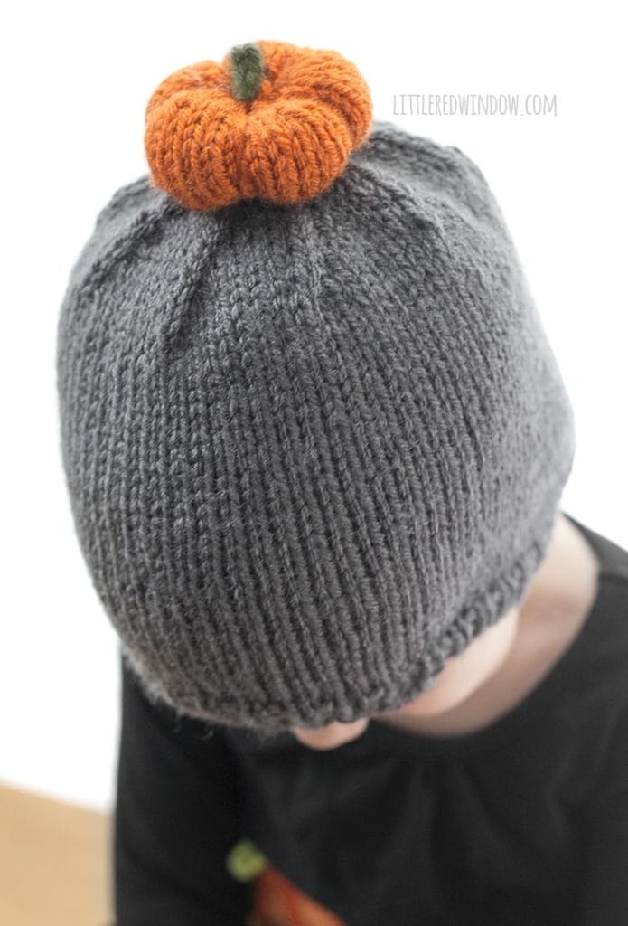 The pumpkin patch hat knitting pattern has a little (adorable) knit pumpkin pom pom on top! It's the perfect fall hat to knit for your baby or toddler!