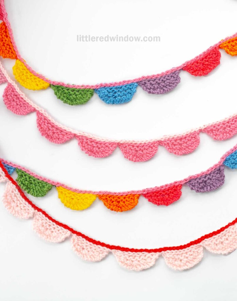 Colorful crochet bunting with scalloped edges displayed against a white background. The bunting features a variety of colors including pink, red, orange, yellow, green, and blue.