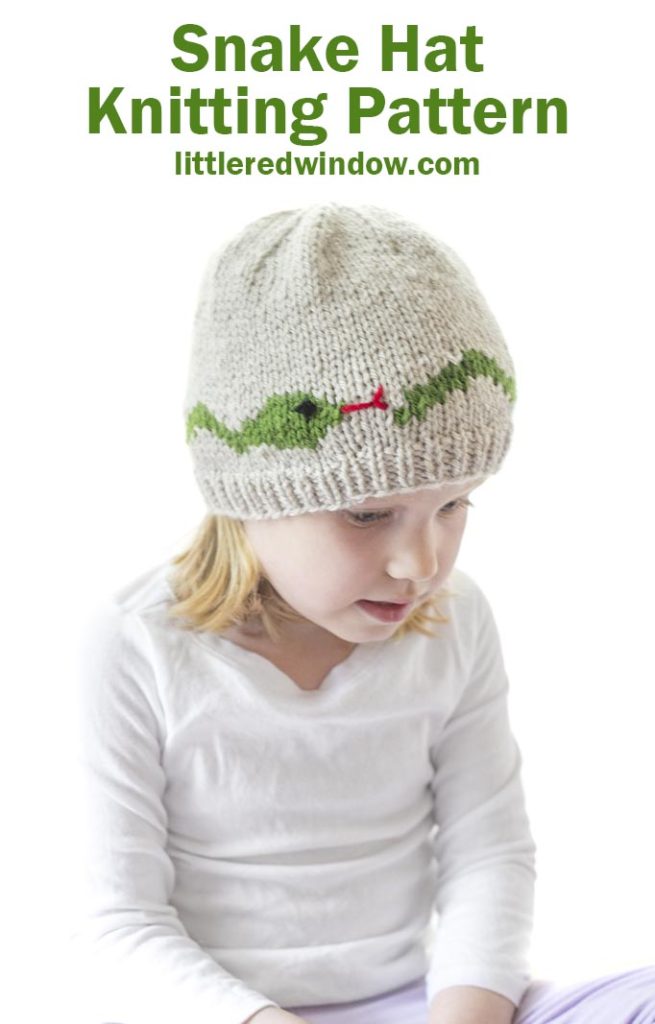 little girl in tan knit hat with a green snake around the middle