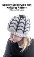 small girl in black shirt wearing white knit hat with spiderweb and spider on it