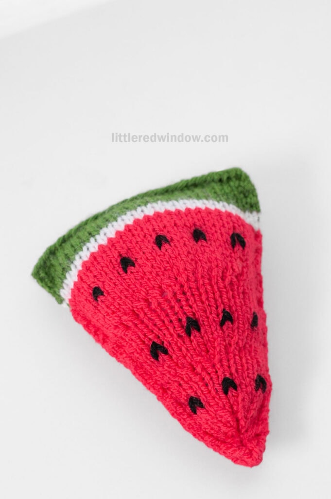 view from slightly above of knit watermelon slice on a light gray background