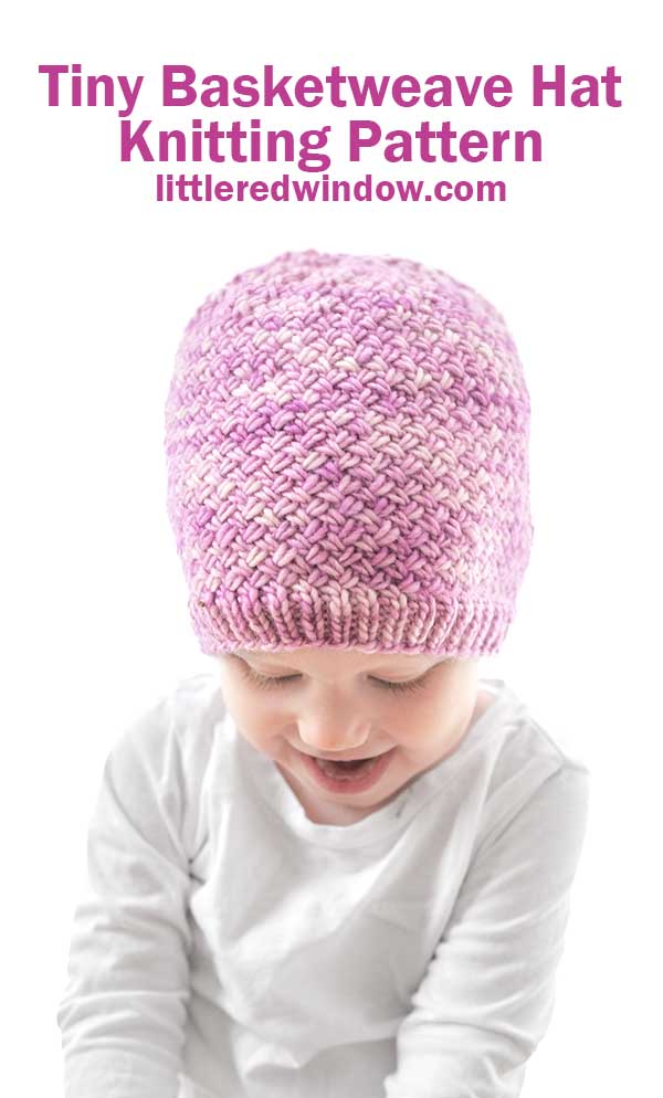 A smiling baby wears a pink, hand-knitted Tiny Basketweave Hat and a white shirt, with text above reading 